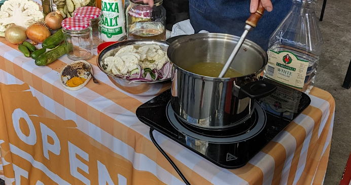 A portable induction stove being used to cook a pot of stew or lentils.